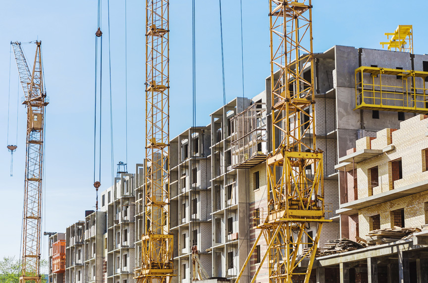 Tower Cranes Performing Work During Construction of Housing Complex