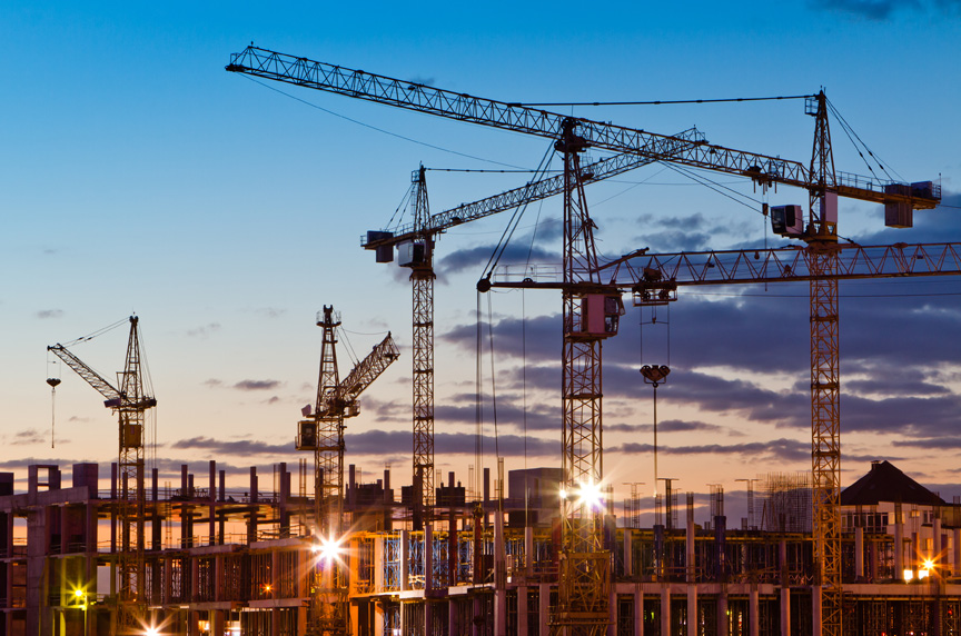 Tower cranes set up at a construction site at dusk