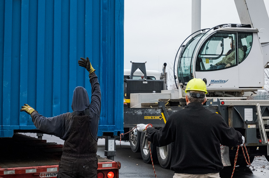 Crane Operator Maneuvering a Load While Signalperson Gives Direction in the Field